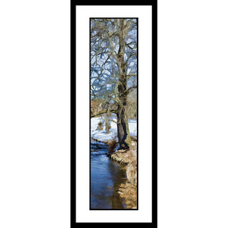 Our Colors of Winter vertical panorama features a striking image of a bare tree and a winter landscape blanketed in snow, near a pond with blue water. Its cool color palette is sure to add a unique, tranquil touch to any space. Colors of Winter by Alison Thomas of Serenity Scenes Photography and Digital Art